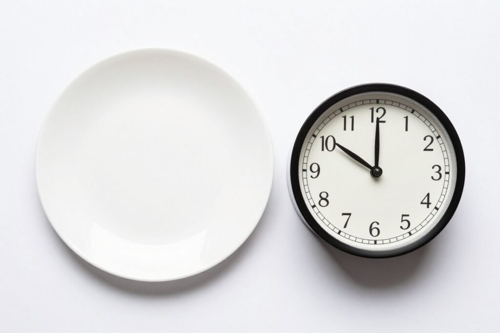 Clock and empty plate representing fasting period of intermittent fasting